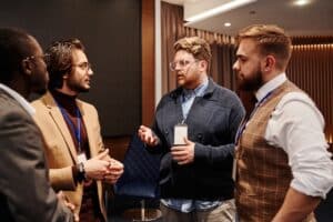 Alt Text: Striking up conversations at corporate events Source: https://www.pexels.com/photo/men-in-discussion-at-an-event-8349431/ 