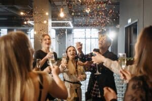Image Source: https://www.pexels.com/photo/people-looking-at-the-confetti-6405783/ Image Text: Team Celebration Alt-Text: Employees Drinking and Celebrating at a Corporate Event Description: Team Celebrating at a Corporate Event