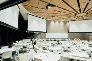 Image Title: Immersive Event Design Alt Text: A photo of an empty conference room with projector screens.   Source: https://unsplash.com/photos/photo-of-empty-room-with-projector-screen-Q_KdjKxntH8 