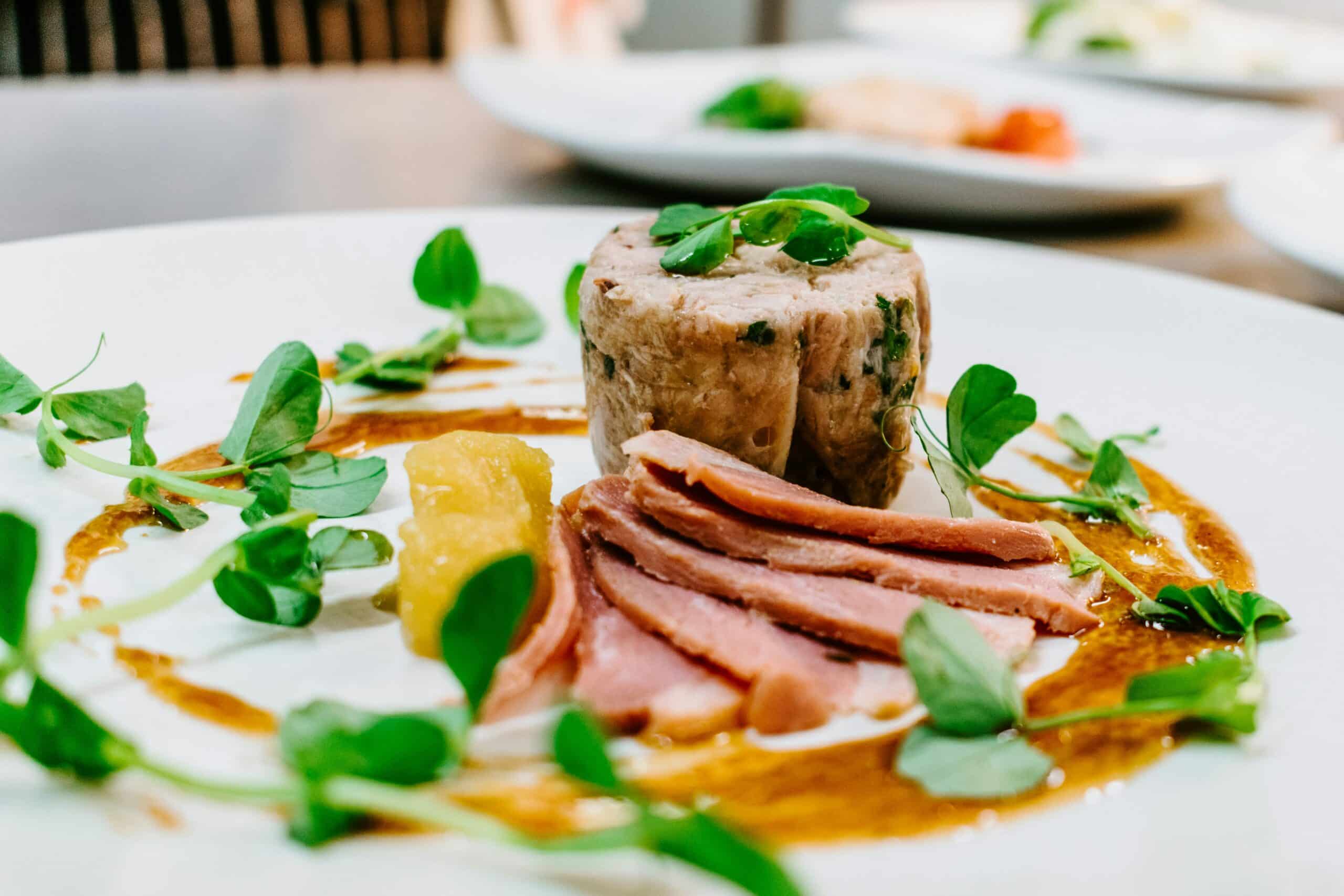 Image title: A focus photograph of cooked meat on a round white plate. Image alt-text: gourmet catering Image URL: https://unsplash.com/photos/selective-focus-photography-of-cooked-meat-on-round-white-plate-7i_YGMy_-Ho 