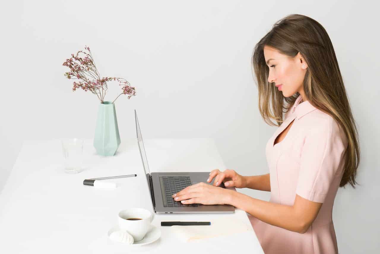 Photo by Moose Photos: https://www.pexels.com/photo/woman-in-pink-dress-using-laptop-computer-1586973/ -- professional woman