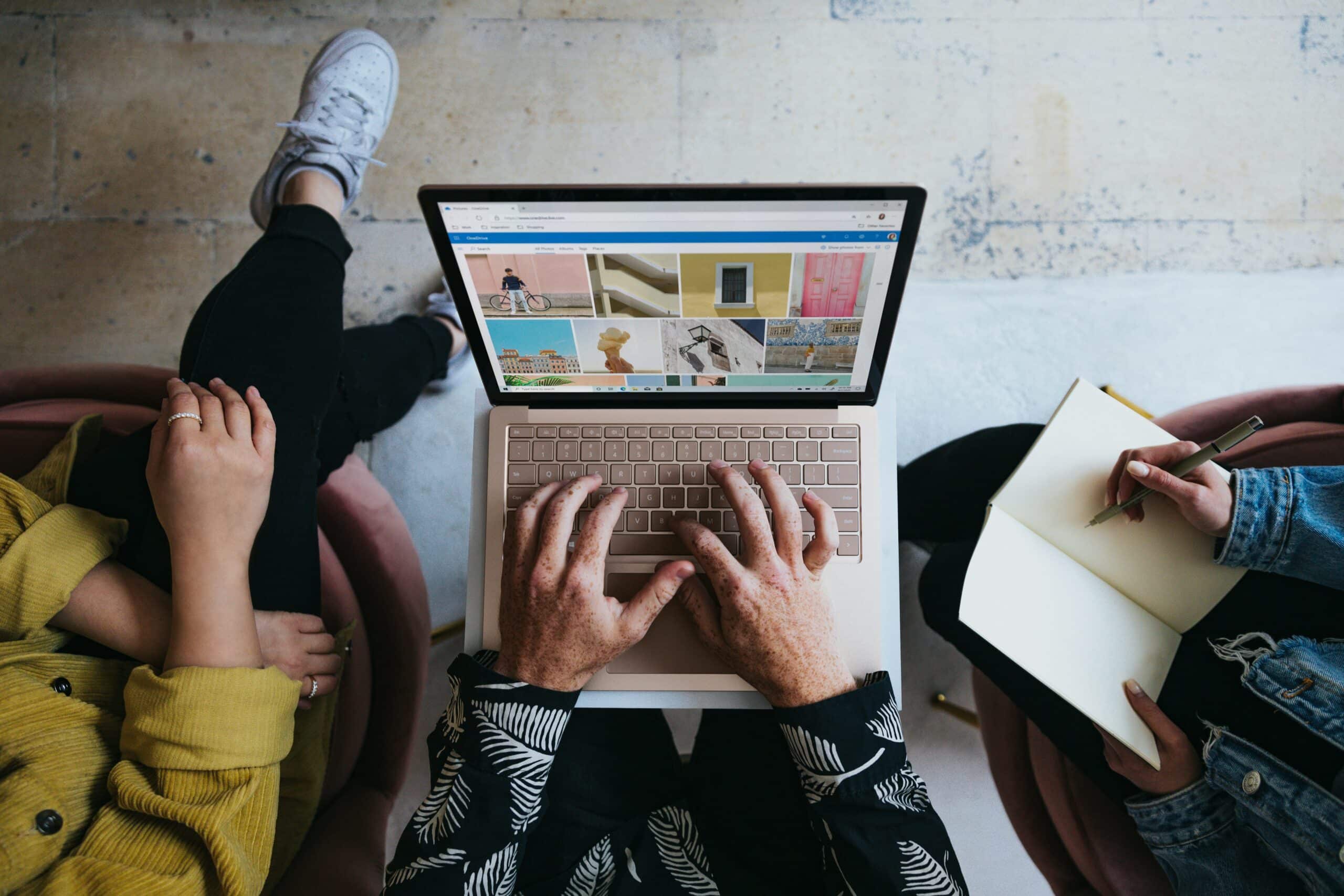 Source: https://unsplash.com/photos/person-using-microsoft-surface-laptop-on-lap-with-two-other-people-w79mIrYKcK4 Title: Niche Selection in Event Planning Alt. Title: Influencer Event Marketing Description: A person checking niche-specific ideas on their computer