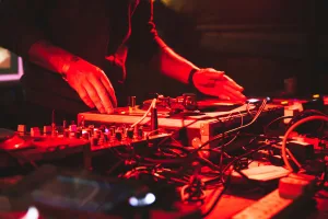https://unsplash.com/photos/a-dj-mixing-music-in-a-dark-room-OXQIWnA7xOU Photo by Tim Macknelly on Unsplash