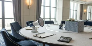 Conference table set for planning the 5 P's of event marketing with notes, a calculator, and a megaphone.