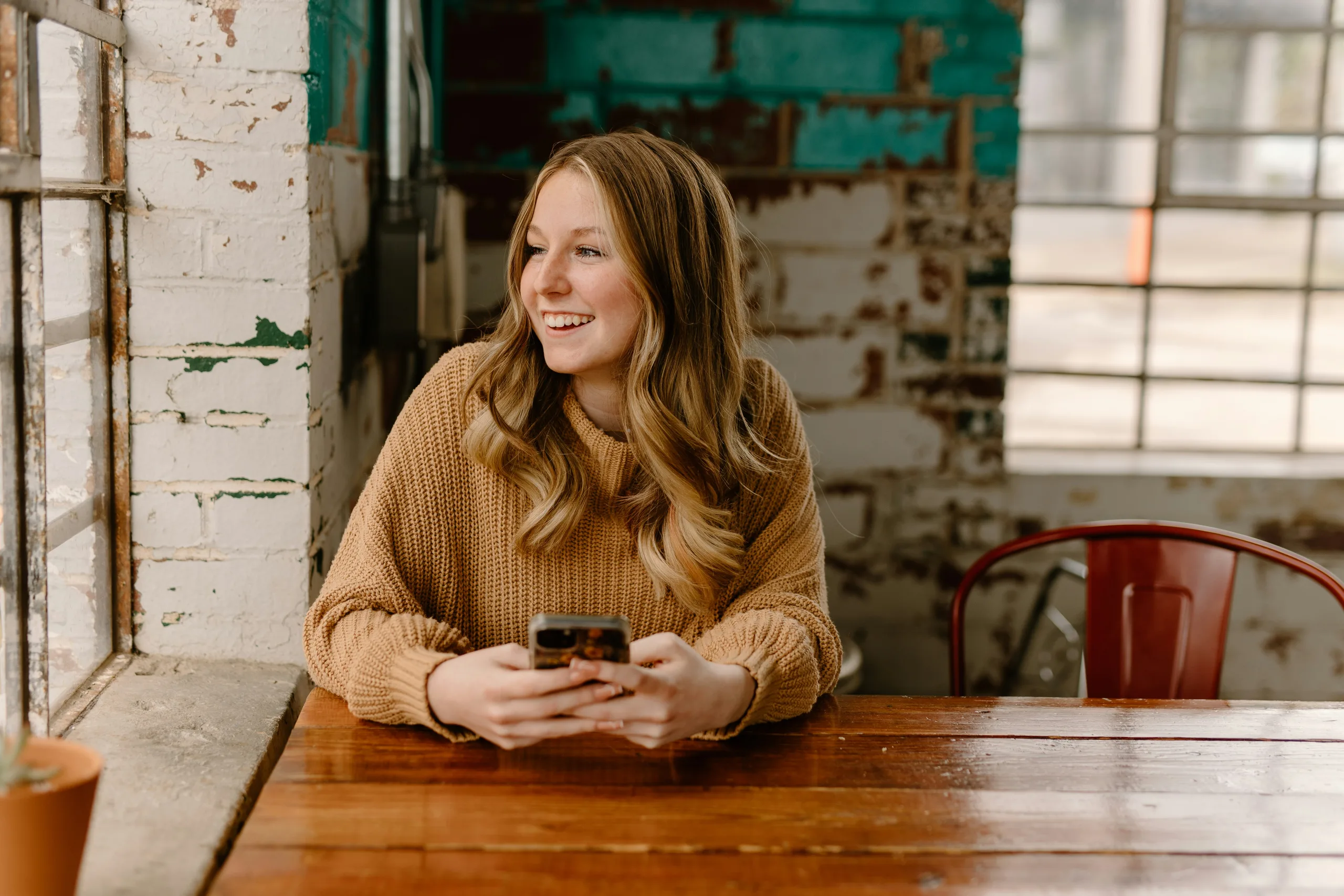 https://unsplash.com/photos/a-woman-sitting-at-a-table-with-a-cell-phone-BMLPa7HBnQQ Photo by Brooke Cagle on Unsplash