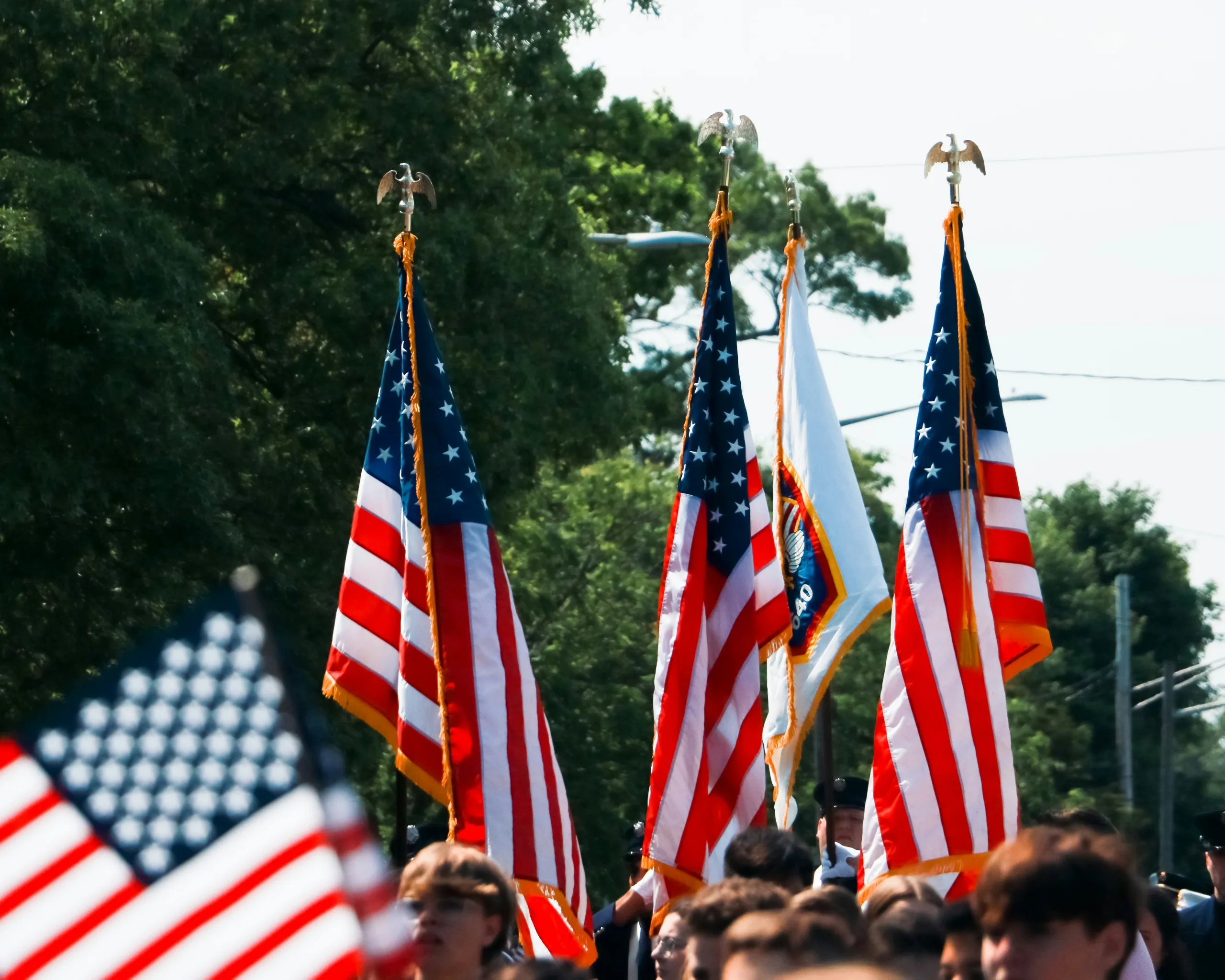 https://unsplash.com/photos/a-group-of-people-walking-down-a-street-holding-american-flags-U1R6CsaDruE Photo by Eli Monjaras on Unsplash