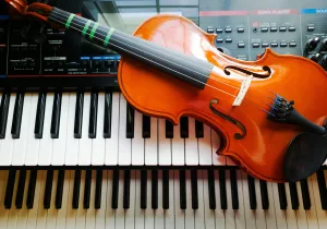 https://unsplash.com/photos/a-violin-sitting-on-top-of-a-piano-keyboard-xXvathfth6E Photo by Lorena Kelly on Unsplash