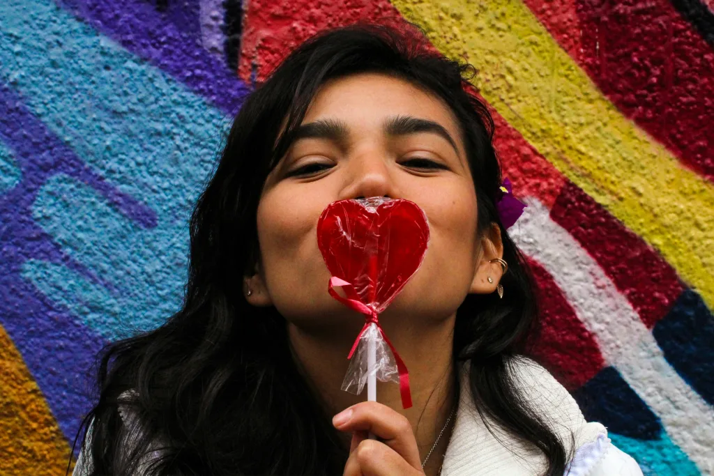 https://unsplash.com/photos/woman-in-white-long-sleeve-shirt-holding-red-lollipop-XIhDS59lQjs Photo by Omar Herrara on Unsplash