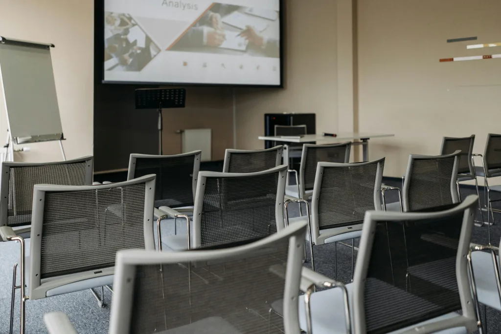 Photo by Pavel Danilyuk: https://www.pexels.com/photo/chairs-arranged-inside-a-conference-room-8761316/