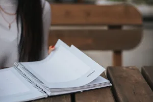https://www.pexels.com/photo/crop-woman-with-notebook-in-park-5239794/