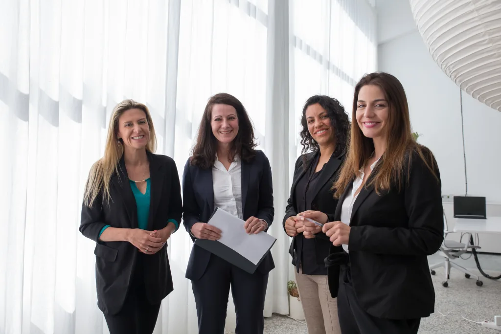 https://www.pexels.com/photo/a-group-of-women-standing-and-smiling-while-wearing-corporate-attire-8171224/