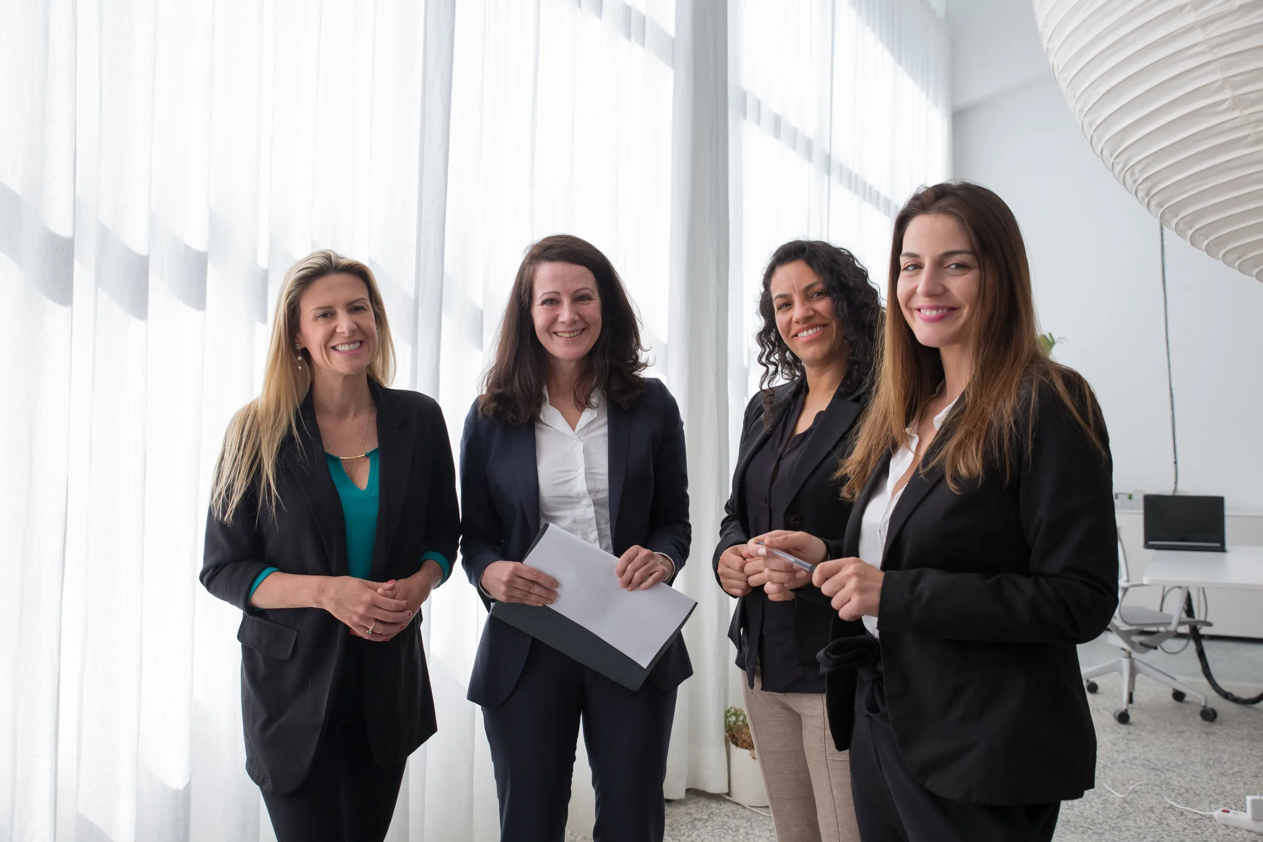 https://www.pexels.com/photo/a-group-of-women-standing-and-smiling-while-wearing-corporate-attire-8171224/