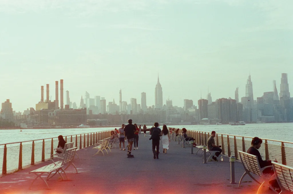 https://unsplash.com/photos/people-stroll-on-pier-with-new-york-city-skyline-background-_IueletALhU