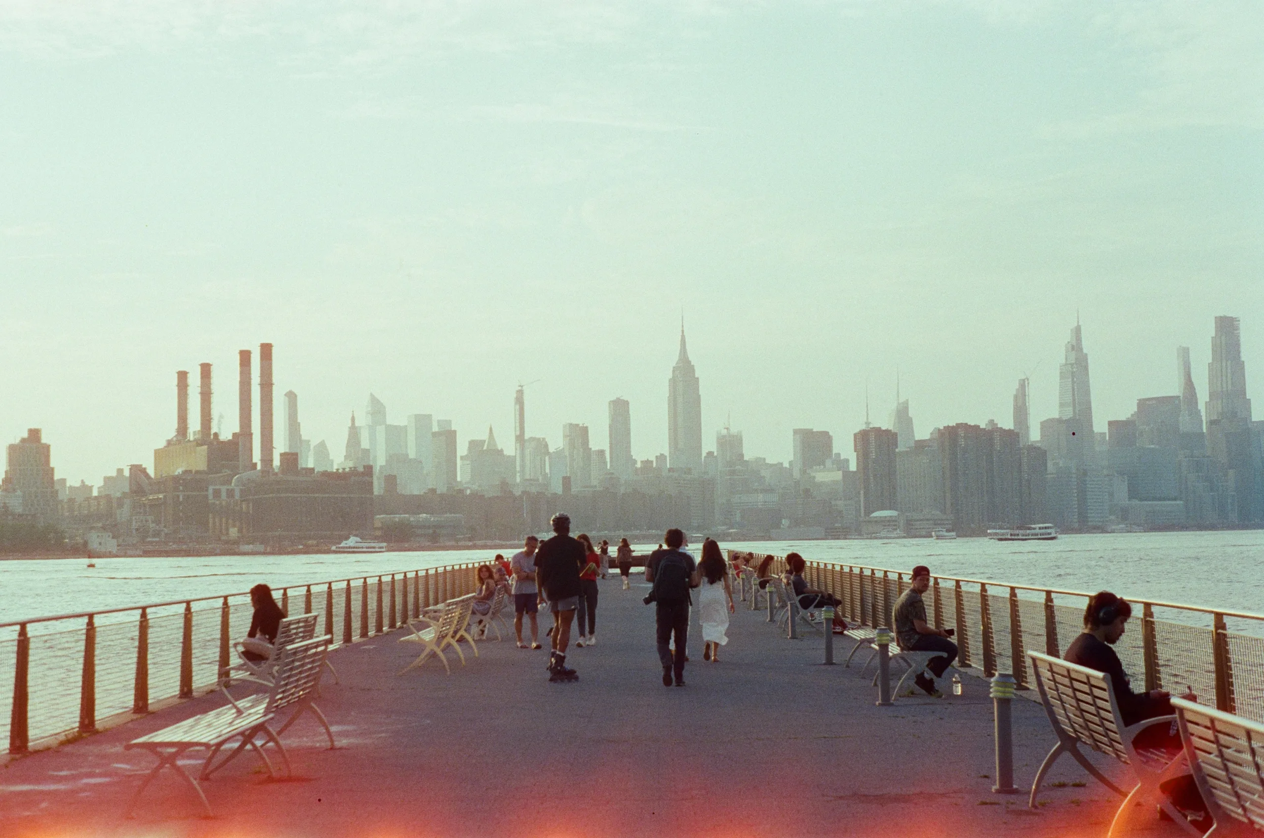 https://unsplash.com/photos/people-stroll-on-pier-with-new-york-city-skyline-background-_IueletALhU