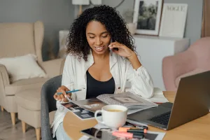 https://www.pexels.com/photo/woman-talking-on-the-phone-and-browsing-through-brochure-5244055/