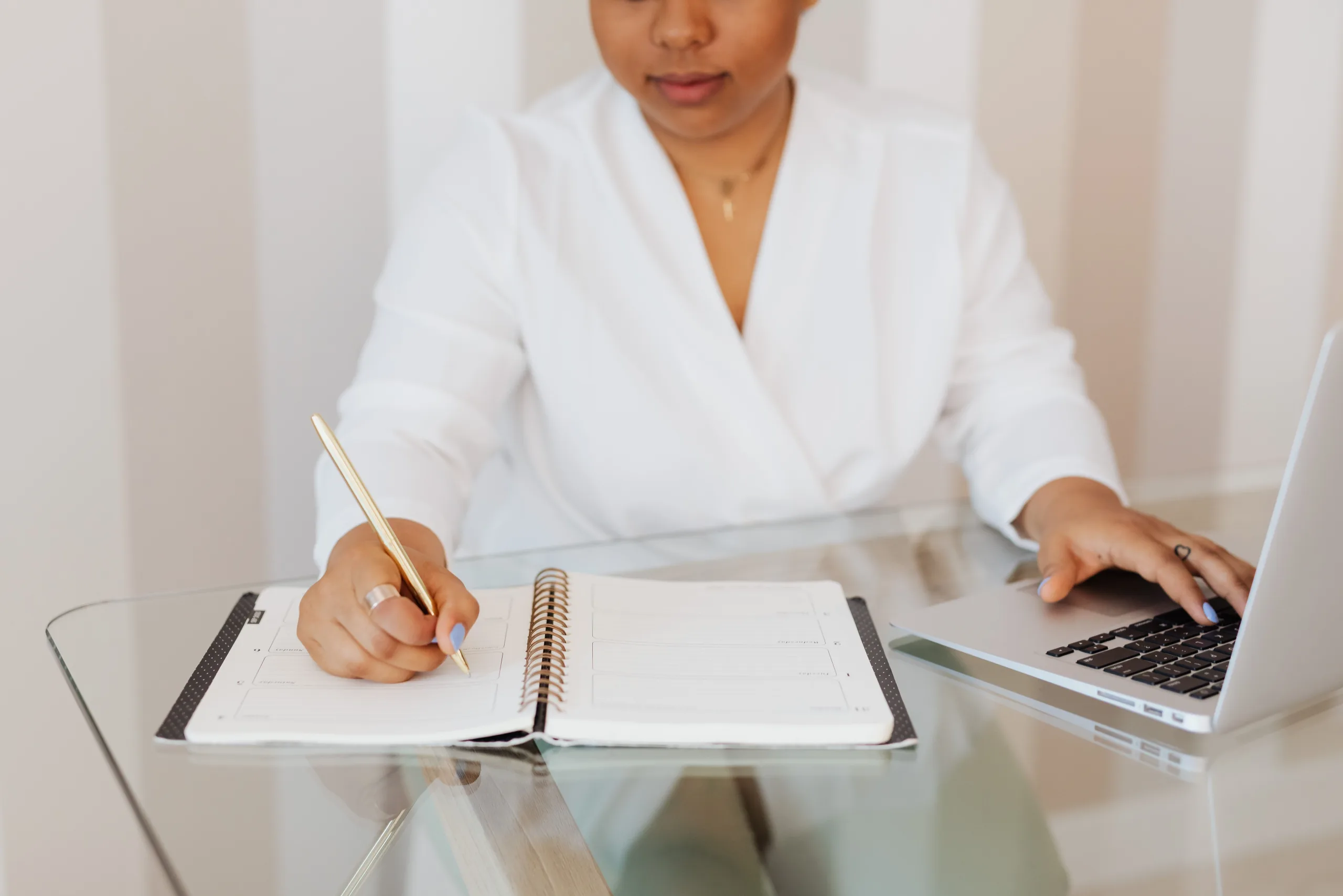 https://www.pexels.com/photo/person-in-white-top-writing-on-notebook-while-using-a-laptop-5387262/
