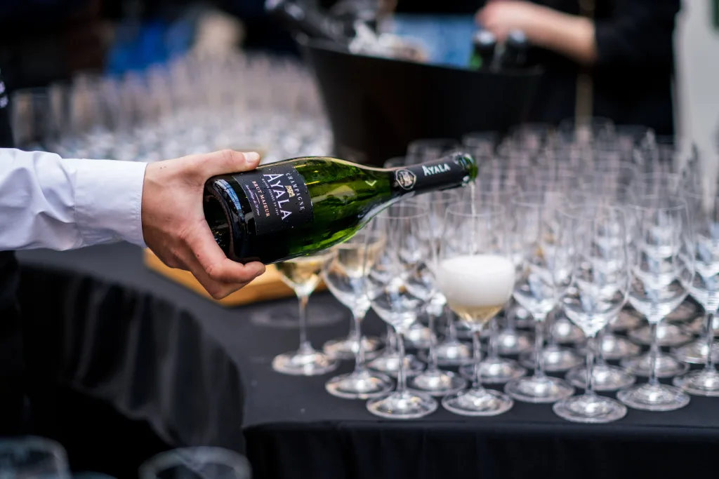 https://www.pexels.com/photo/a-person-pouring-champagne-into-glasses-16125869/