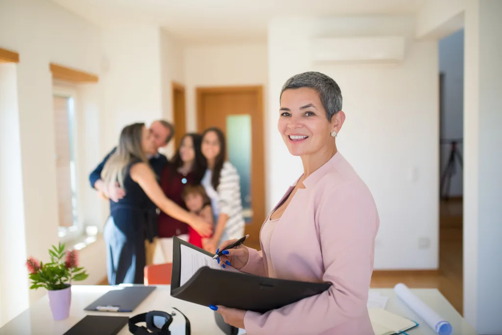 https://www.pexels.com/photo/real-estate-agent-holding-documents-and-a-family-hugging-in-the-background-8730026/